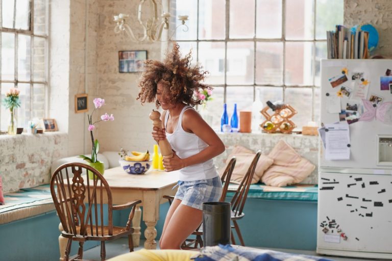 Happy woman dancing in her apartment