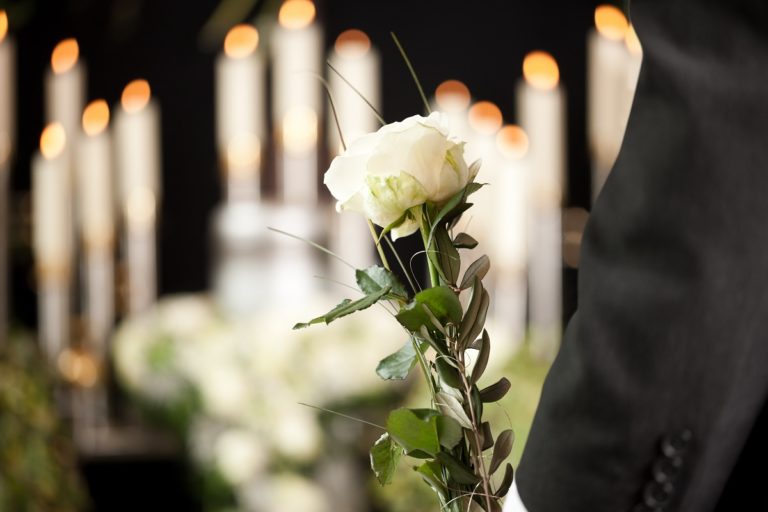 Man holding a white flower in the funeral