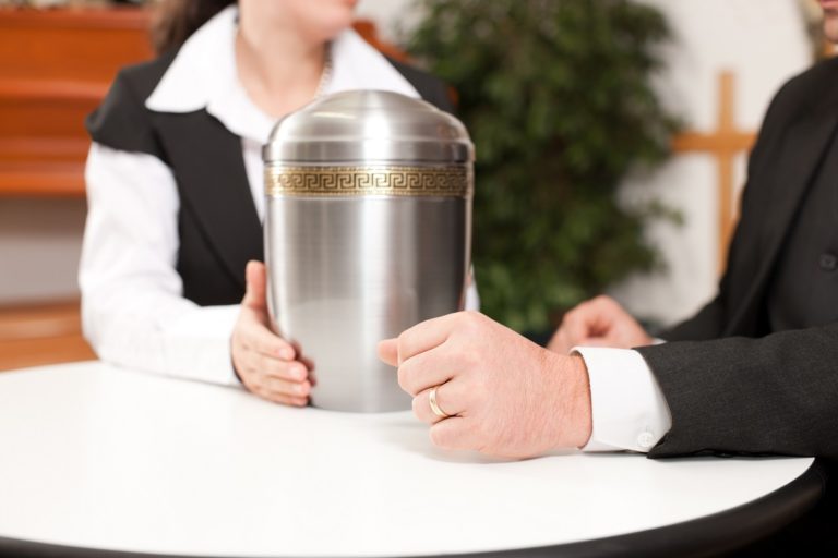 Mortician handing the stainless urn
