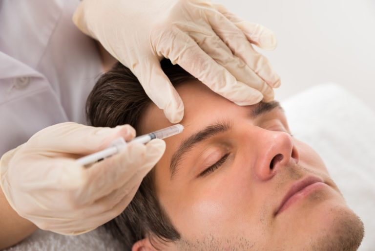 Young Man Having Botox Treatment At Beauty Clinic