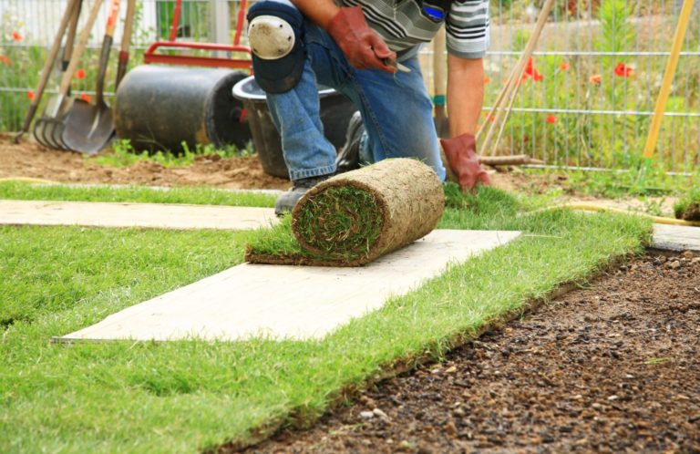 landscape worker laying fake grass