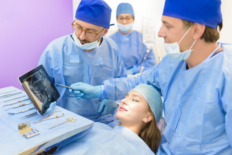 dentist showing her patient's teeth xray before surgery