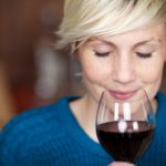 Closeup portrait of young female customer drinking red wine with eyes closed