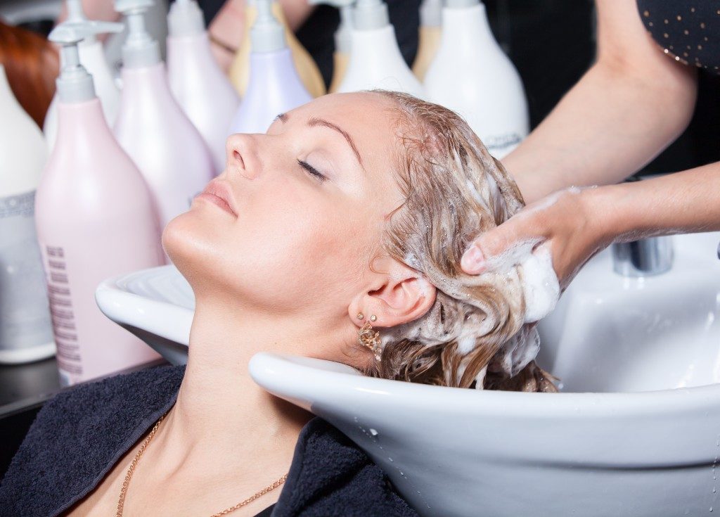 Hair washing at a hairdressing salon, young caucasian girl