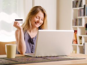 woman excited about online shopping with her laptop and credit card