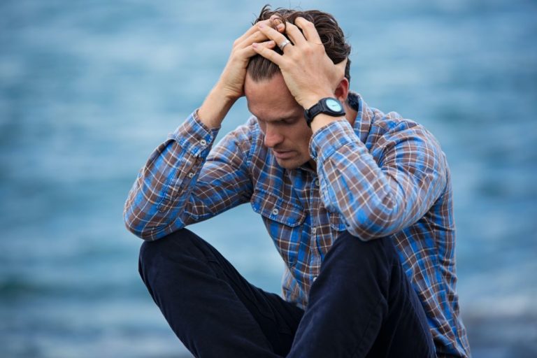 man holding his head with his hands