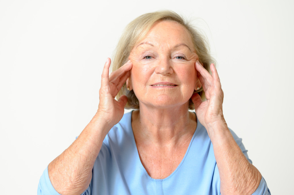 elderly woman pushing back her wrinkles
