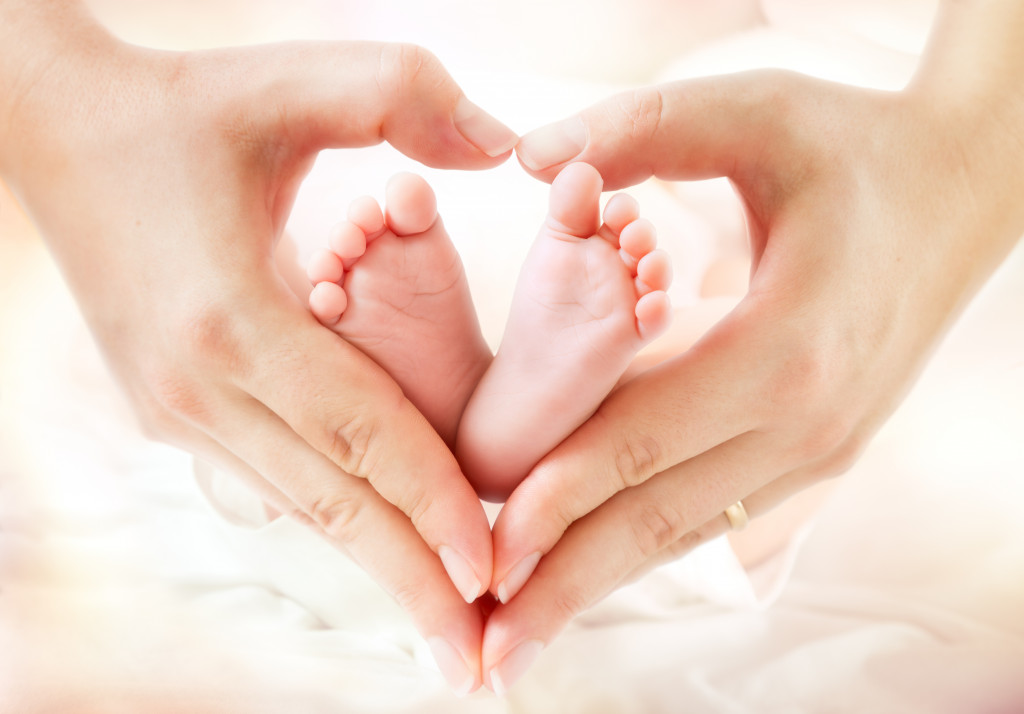baby feet in mother hands in a heart shape