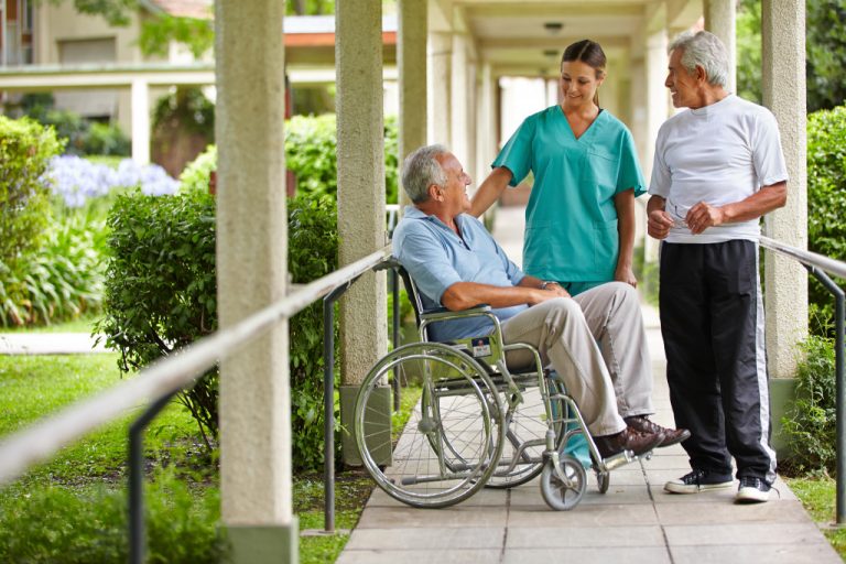 two senior talking to a nurse on a pathway